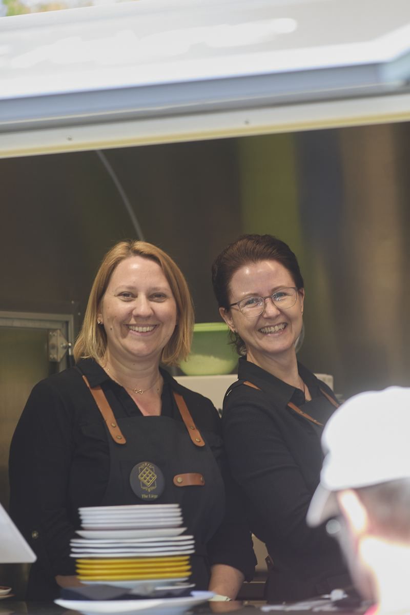 Zwei Frauen vom Team lachen im Trailer