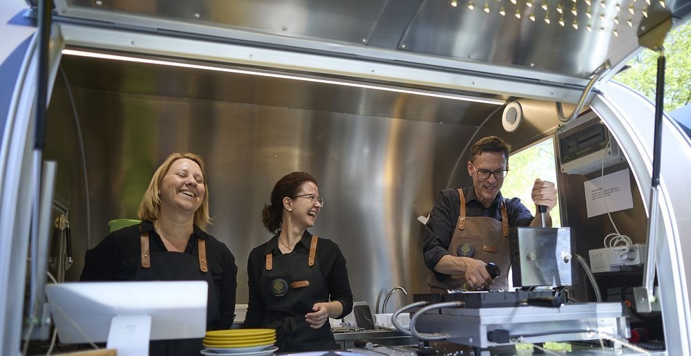 Das Team von The Liège lachend im Waffeltrailer